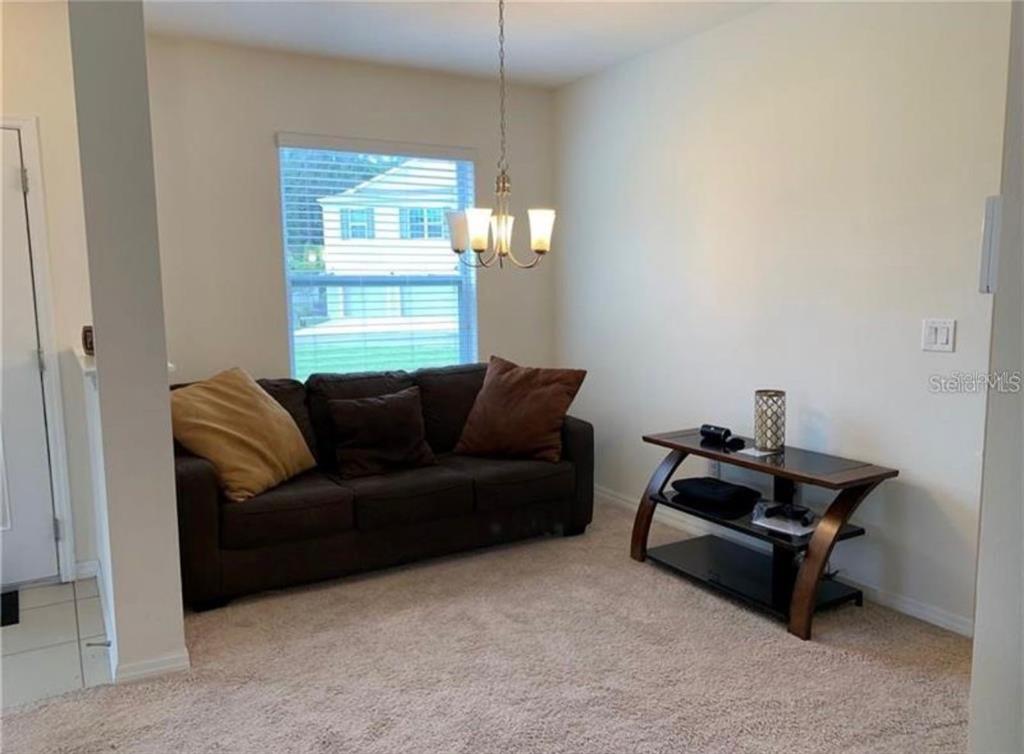 3740 Seneca Club Loop Orlando, FL 32808 - Photo 10 of 15 a living room with a couch and a window