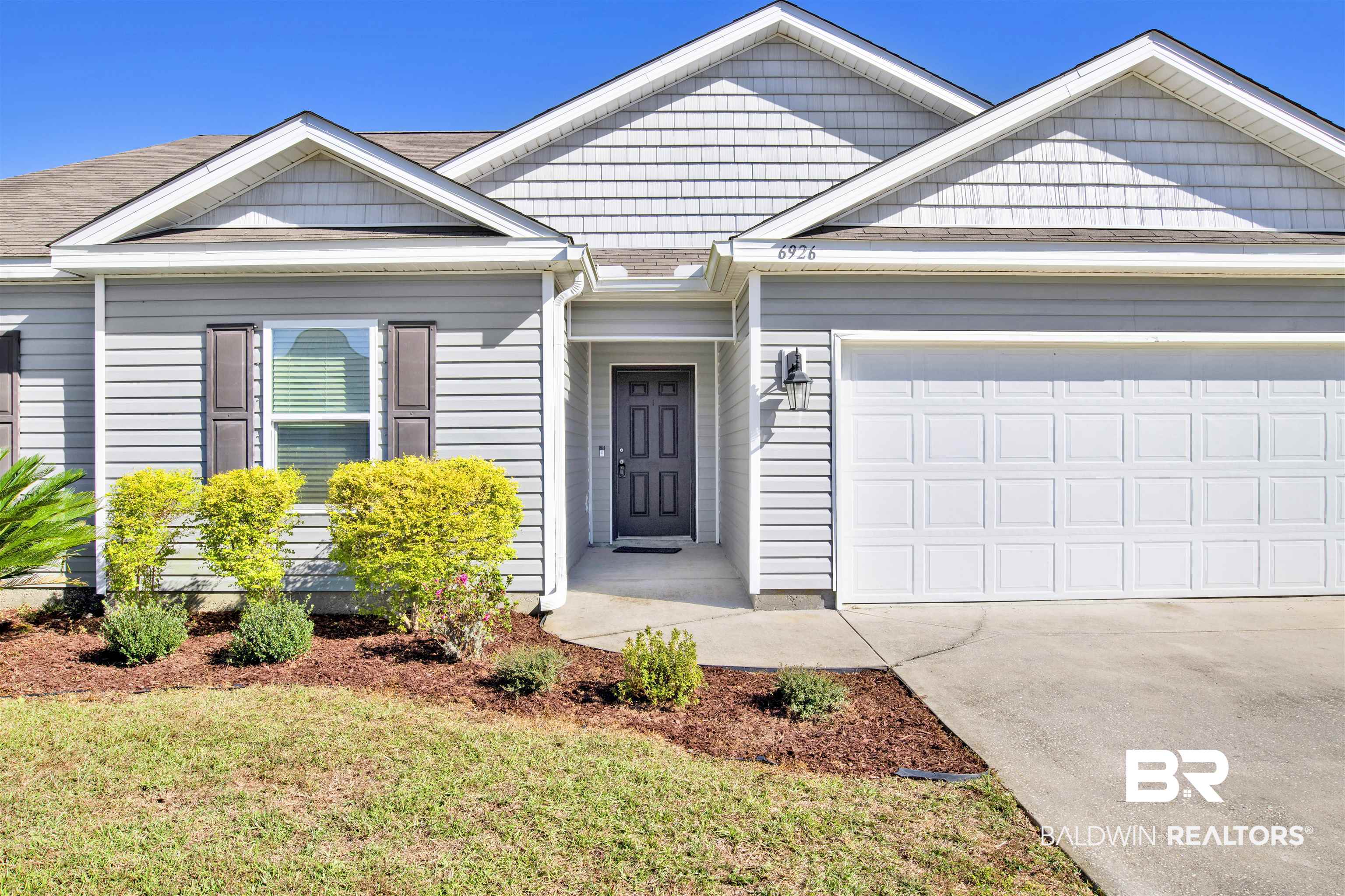 6926 Crimson Ridge Street Gulf Shores, AL 36542 - Photo 2 of 18 View of front of home featuring driveway, a garage, and a front lawn