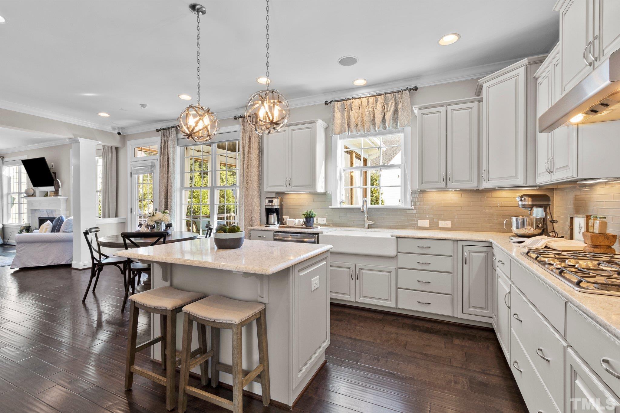 2830 Riley's Pond Drive Apex, NC 27502 - Photo 14 of 54 a kitchen with stainless steel appliances kitchen island a large island in the center cabinets and a large window