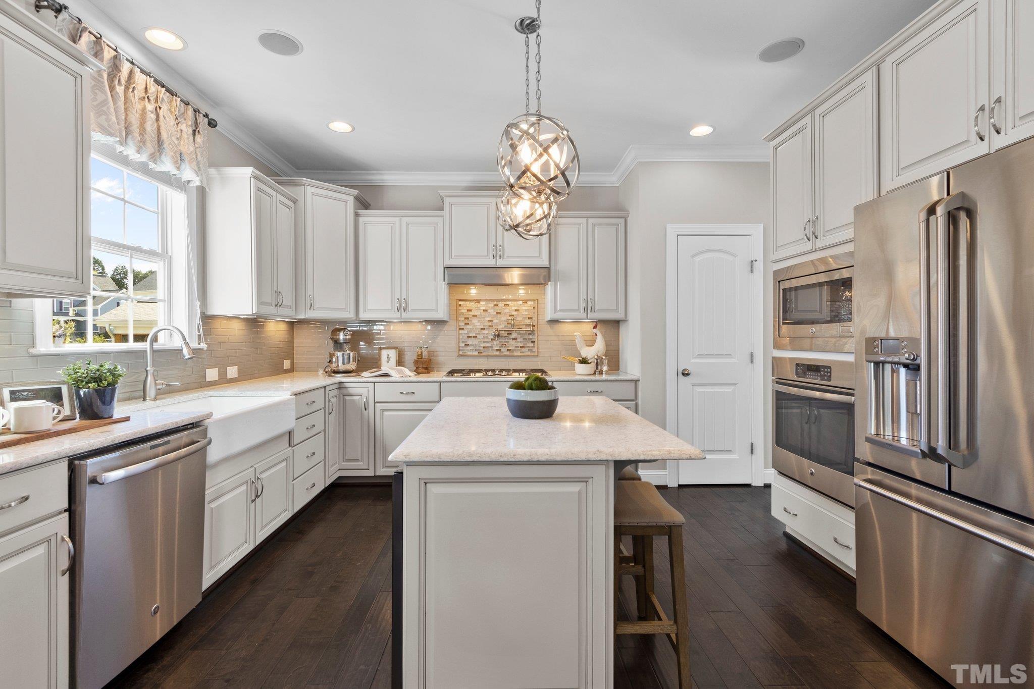 2830 Riley's Pond Drive Apex, NC 27502 - Photo 17 of 54 a kitchen with white cabinets and stainless steel appliances