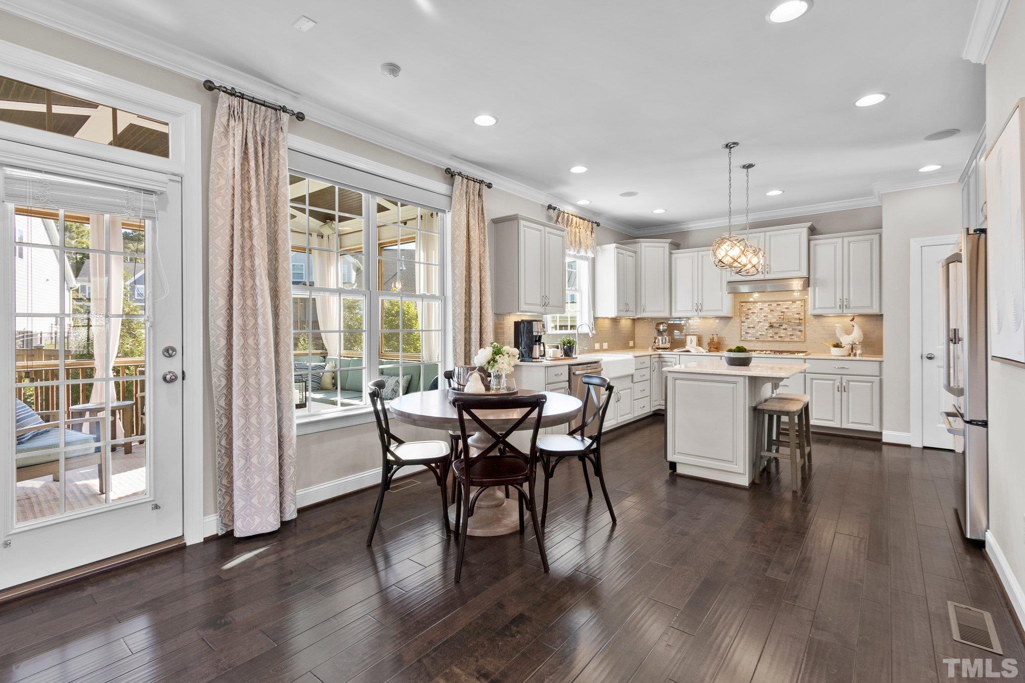 2830 Riley's Pond Drive Apex, NC 27502 - Photo 19 of 54 a kitchen with a table chairs refrigerator microwave and cabinets
