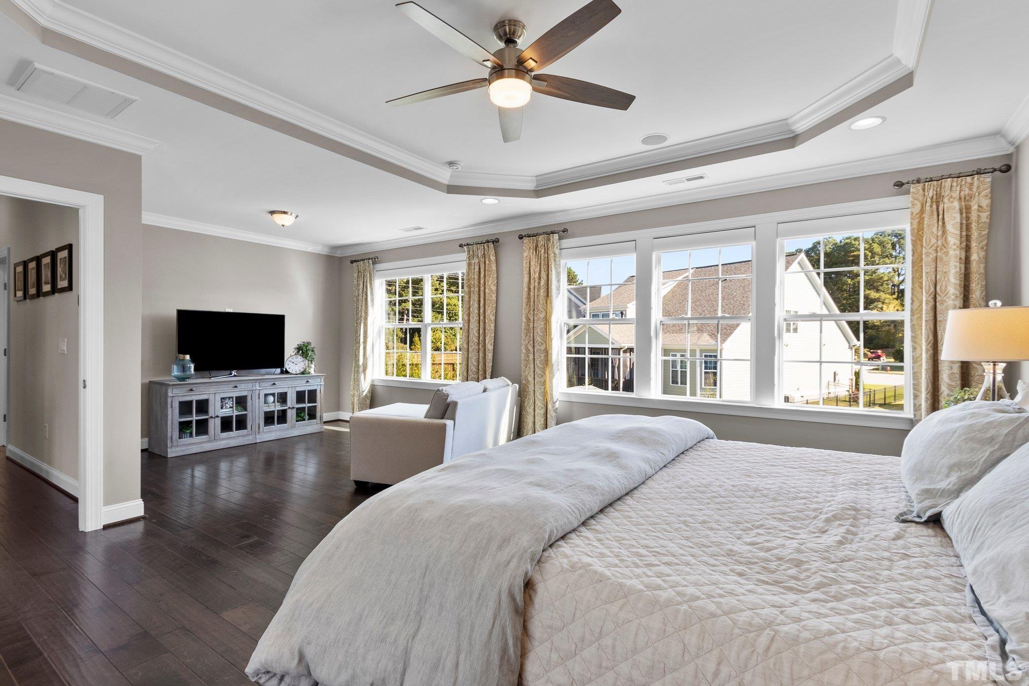 2830 Riley's Pond Drive Apex, NC 27502 - Photo 22 of 54 a bedroom with a bed and a flat screen tv with wooden floor