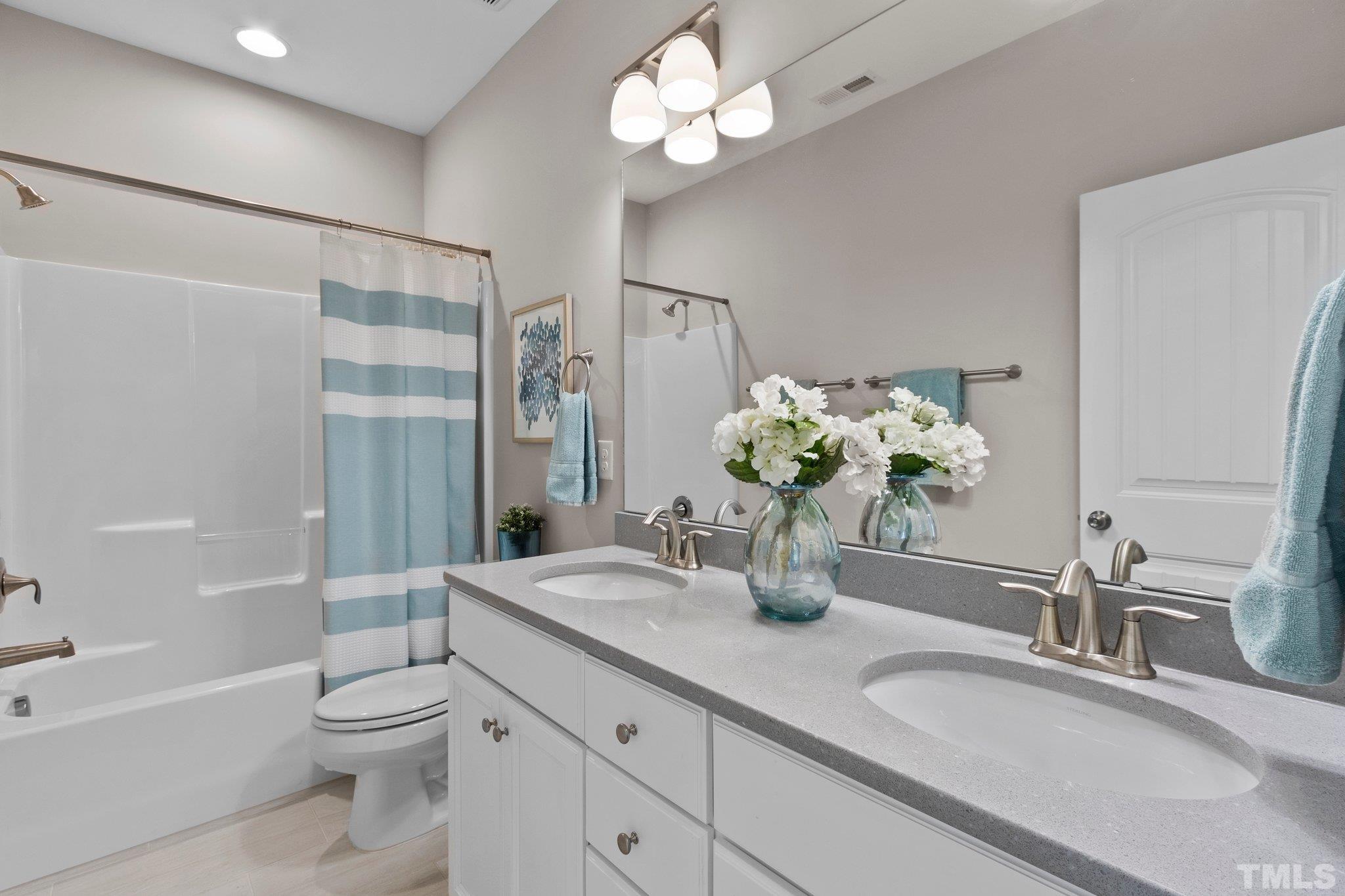 2830 Riley's Pond Drive Apex, NC 27502 - Photo 28 of 54 a bathroom with a granite countertop sink a toilet and a mirror