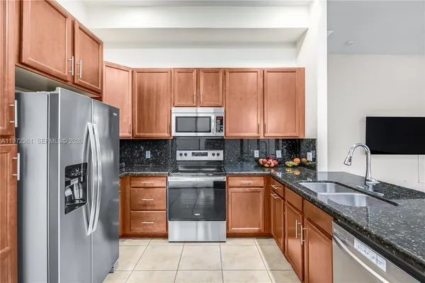 a kitchen with stainless steel appliances granite countertop a refrigerator sink and cabinets