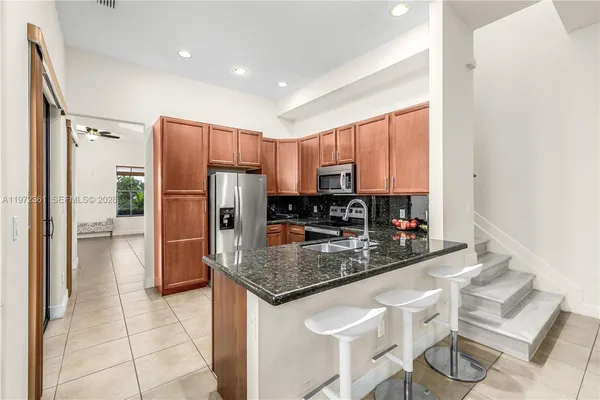 a kitchen with stainless steel appliances granite countertop a refrigerator and a stove top oven