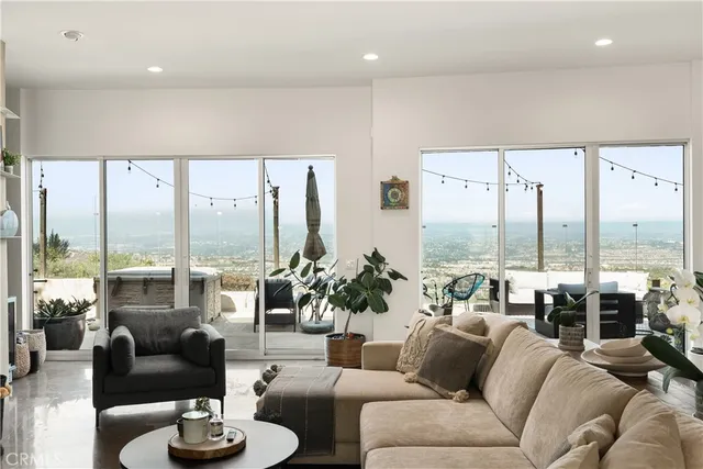 a living room with furniture a flat screen tv and a floor to ceiling window