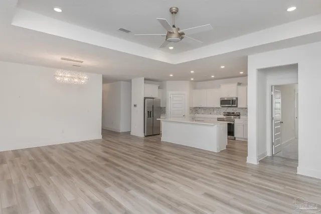 a view of kitchen with granite countertop cabinets and refrigerator