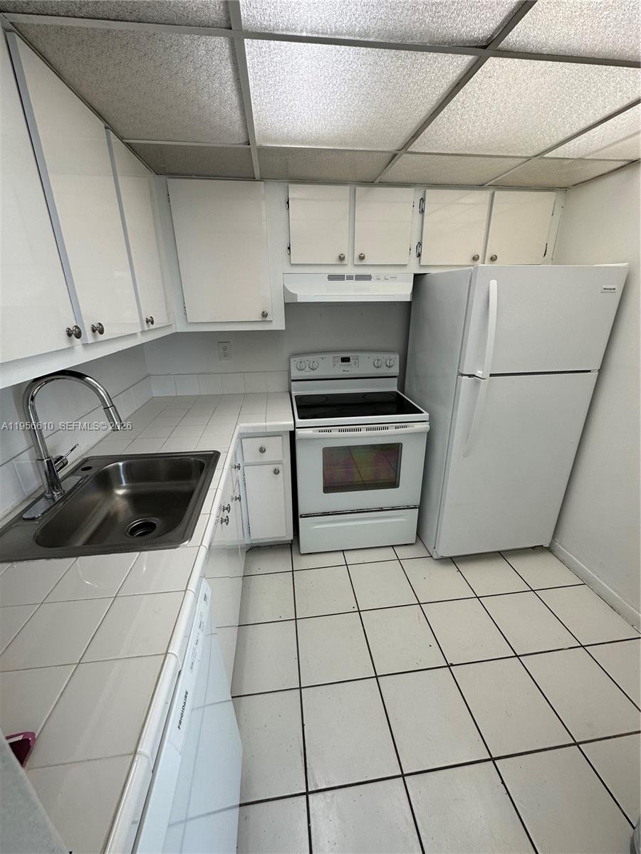 486 Northwest 165th Street, Unit B501 Miami, FL 33169 - Photo 2 of 14 a kitchen with a stove a microwave and a sink