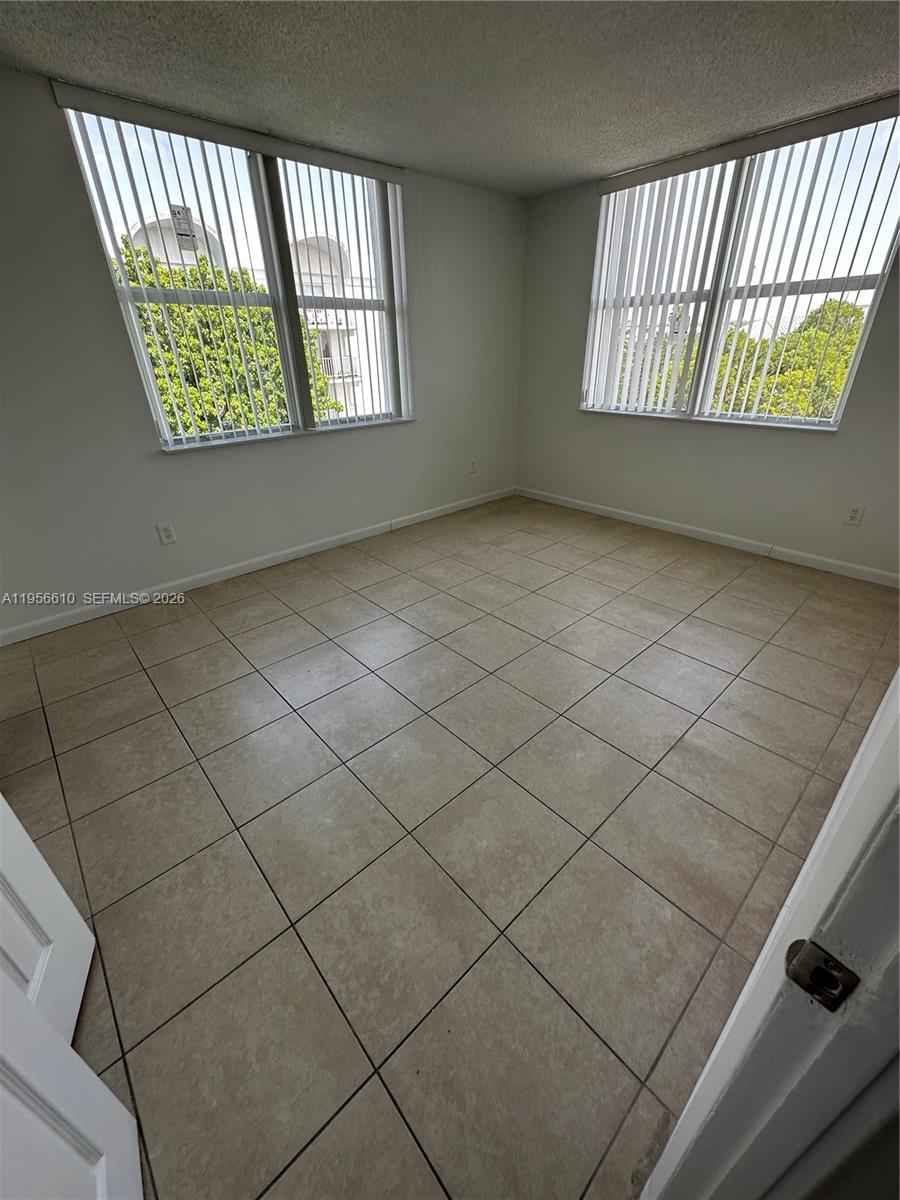 486 Northwest 165th Street, Unit B501 Miami, FL 33169 - Photo 5 of 14 a view of an empty room and window