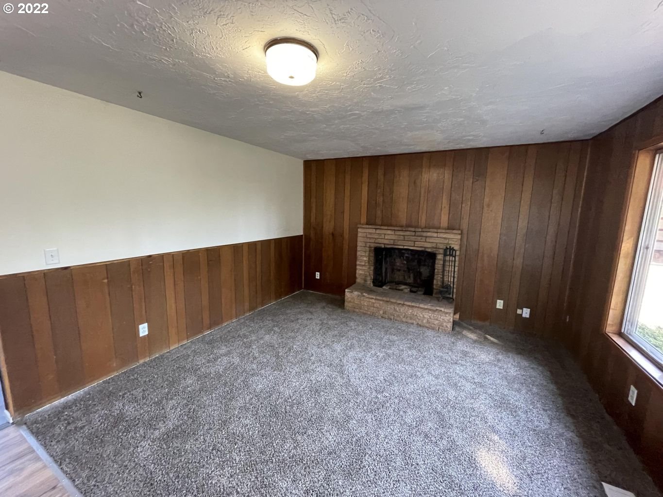 5970 Brickyard Road Tillamook, OR 97141 - Photo 3 of 32 an empty room with fireplace and windows