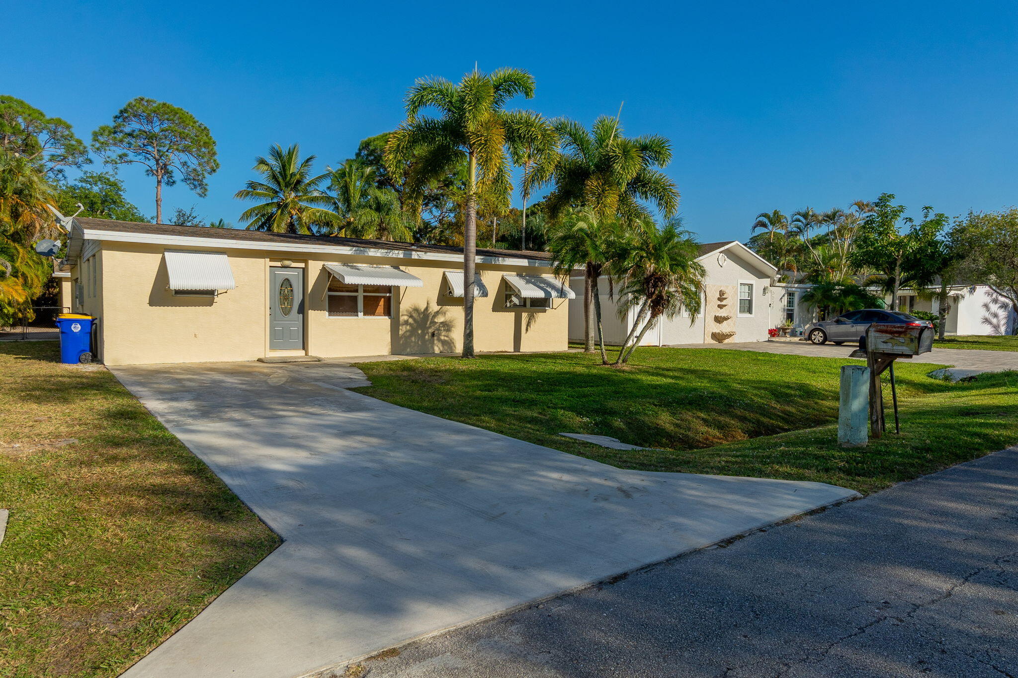 a front view of a house with a yard and potted plants