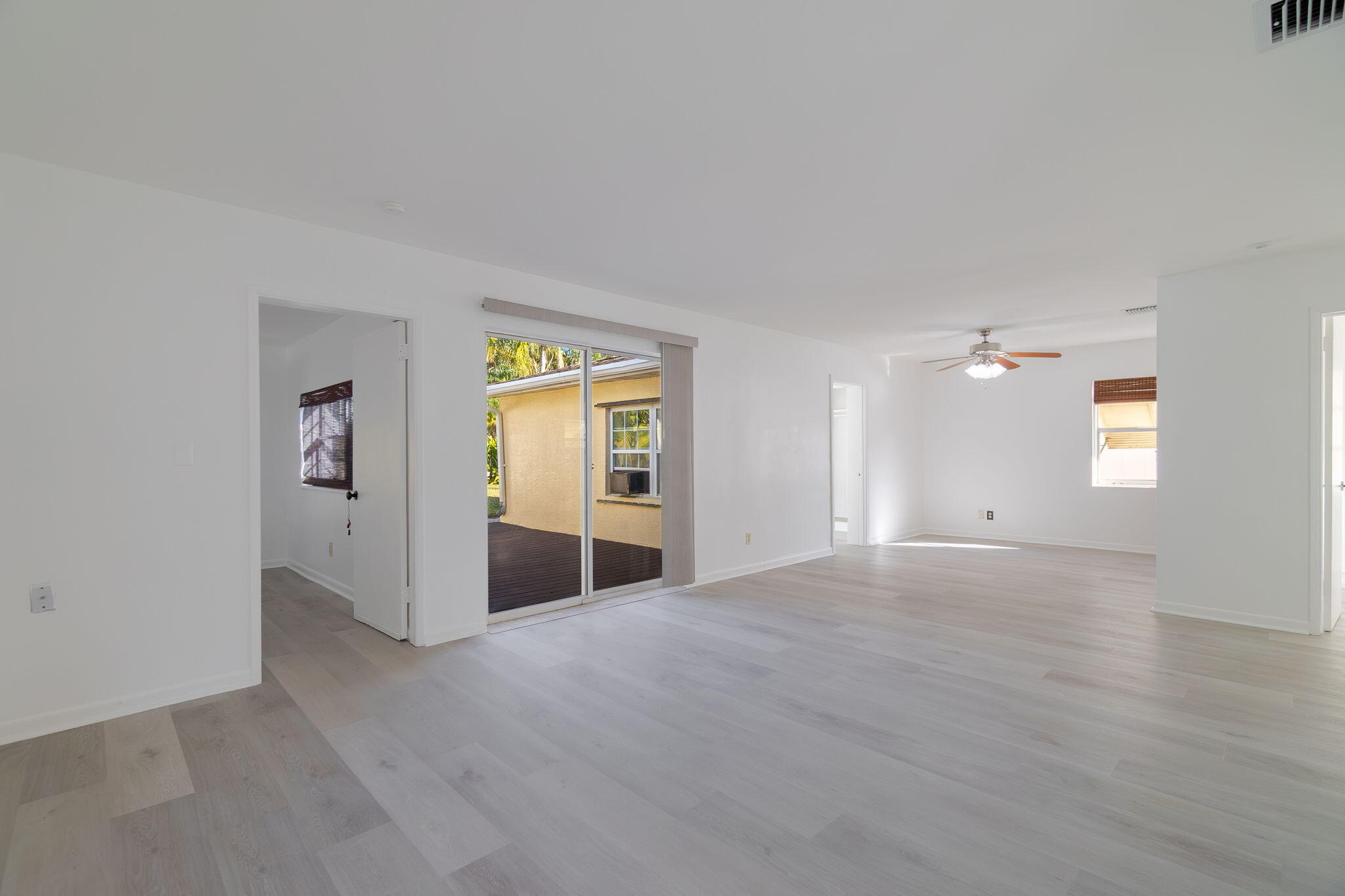5519 Southeast Normandy Avenue Stuart, FL 34997 - Photo 5 of 38 a view of empty room with wooden floor and windows
