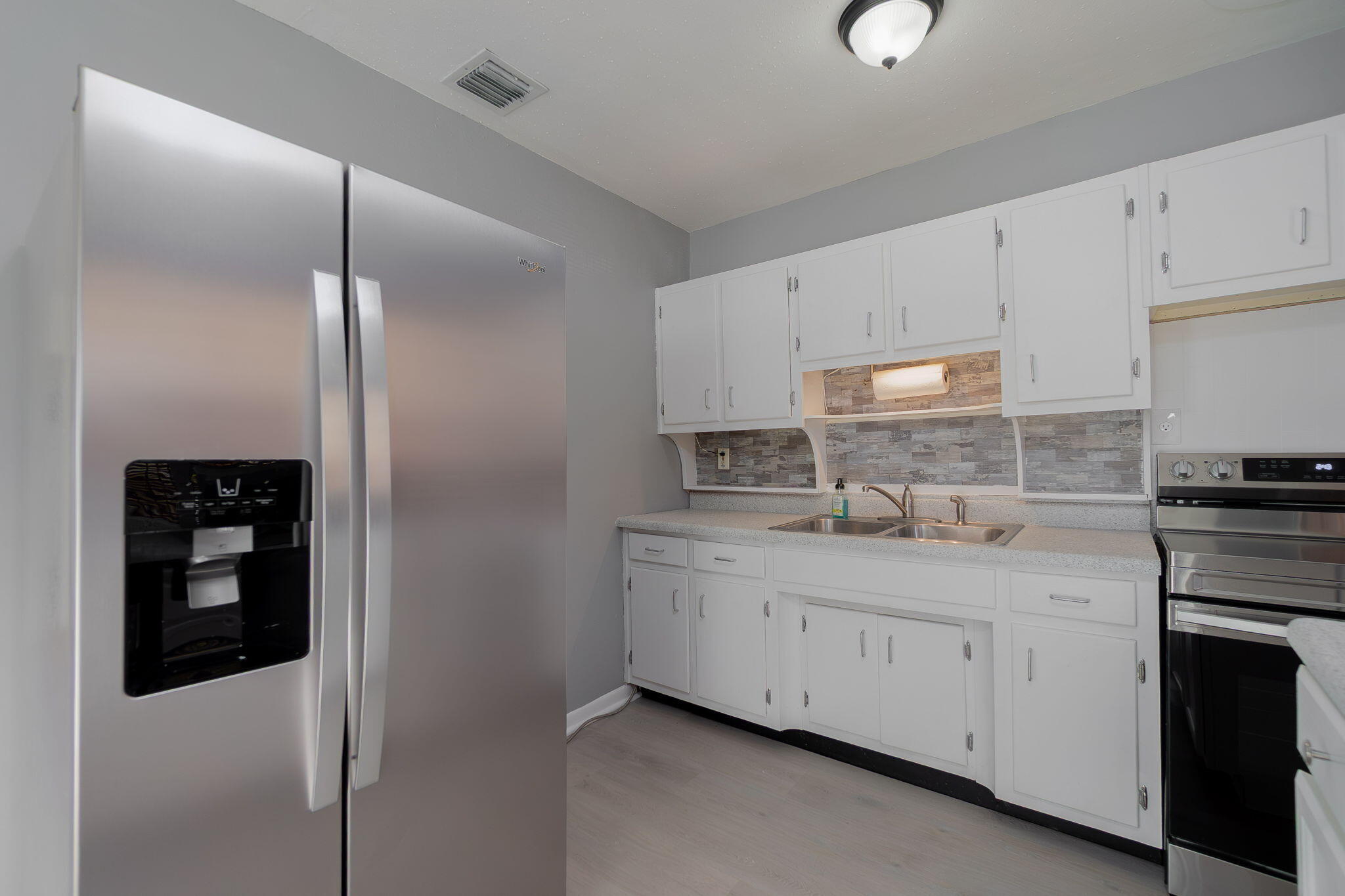 5519 Southeast Normandy Avenue Stuart, FL 34997 - Photo 9 of 38 a kitchen with white cabinets and appliances