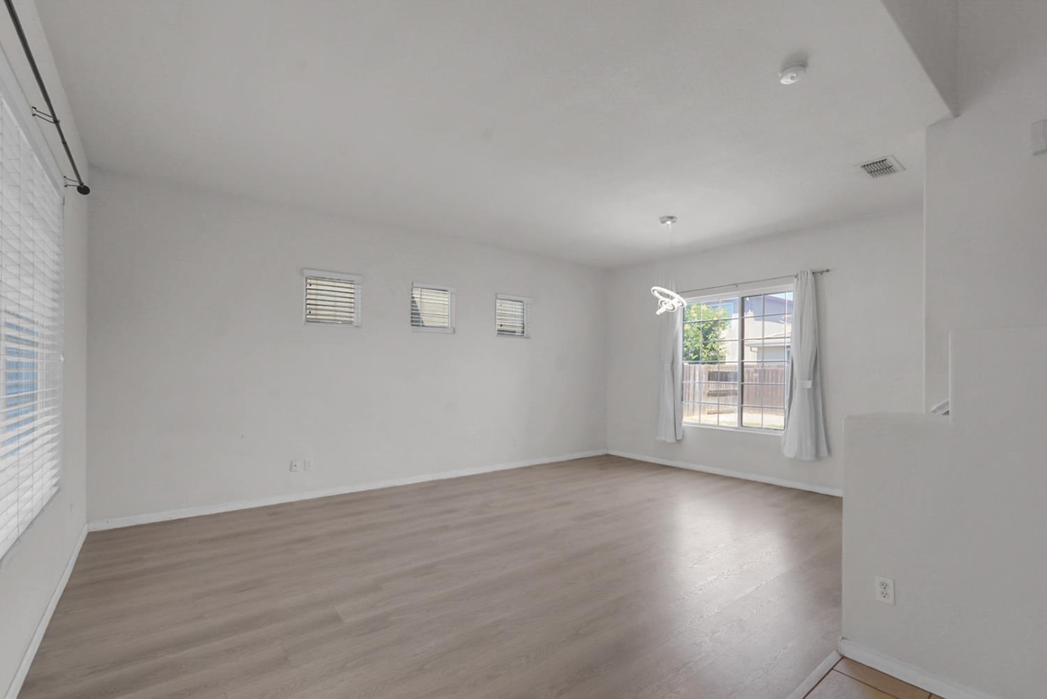 1412 Red Ribbons Lane Manteca, CA 95337 - Photo 4 of 32 an empty room with wooden floor and windows