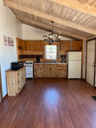 a kitchen with stove and wooden floor