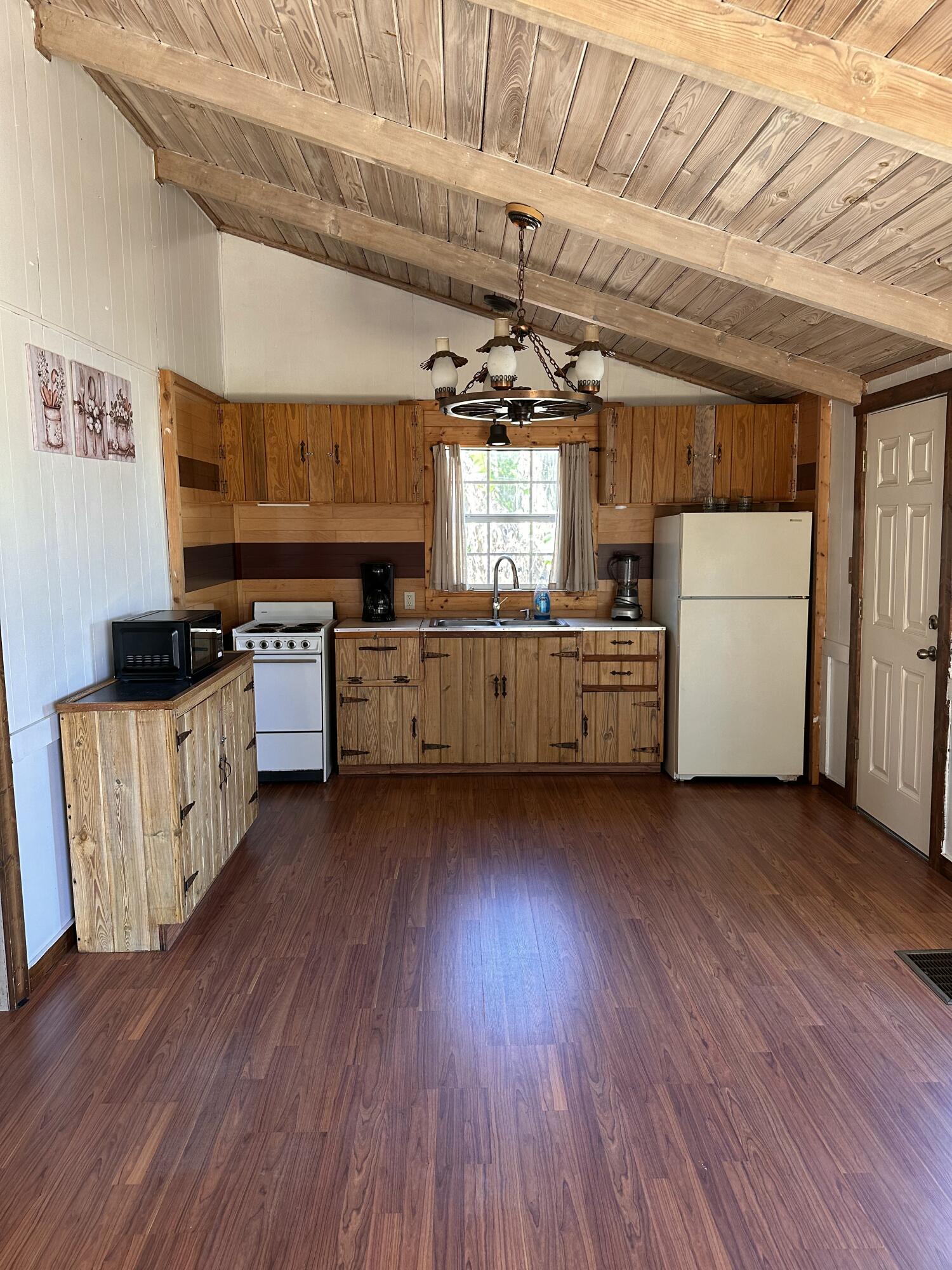 14455 Highway 78 Okeechobee, FL 34974 - Photo 2 of 14 a kitchen with stove and wooden floor