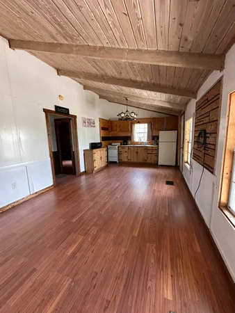 a view of a room with wooden floors and furniture