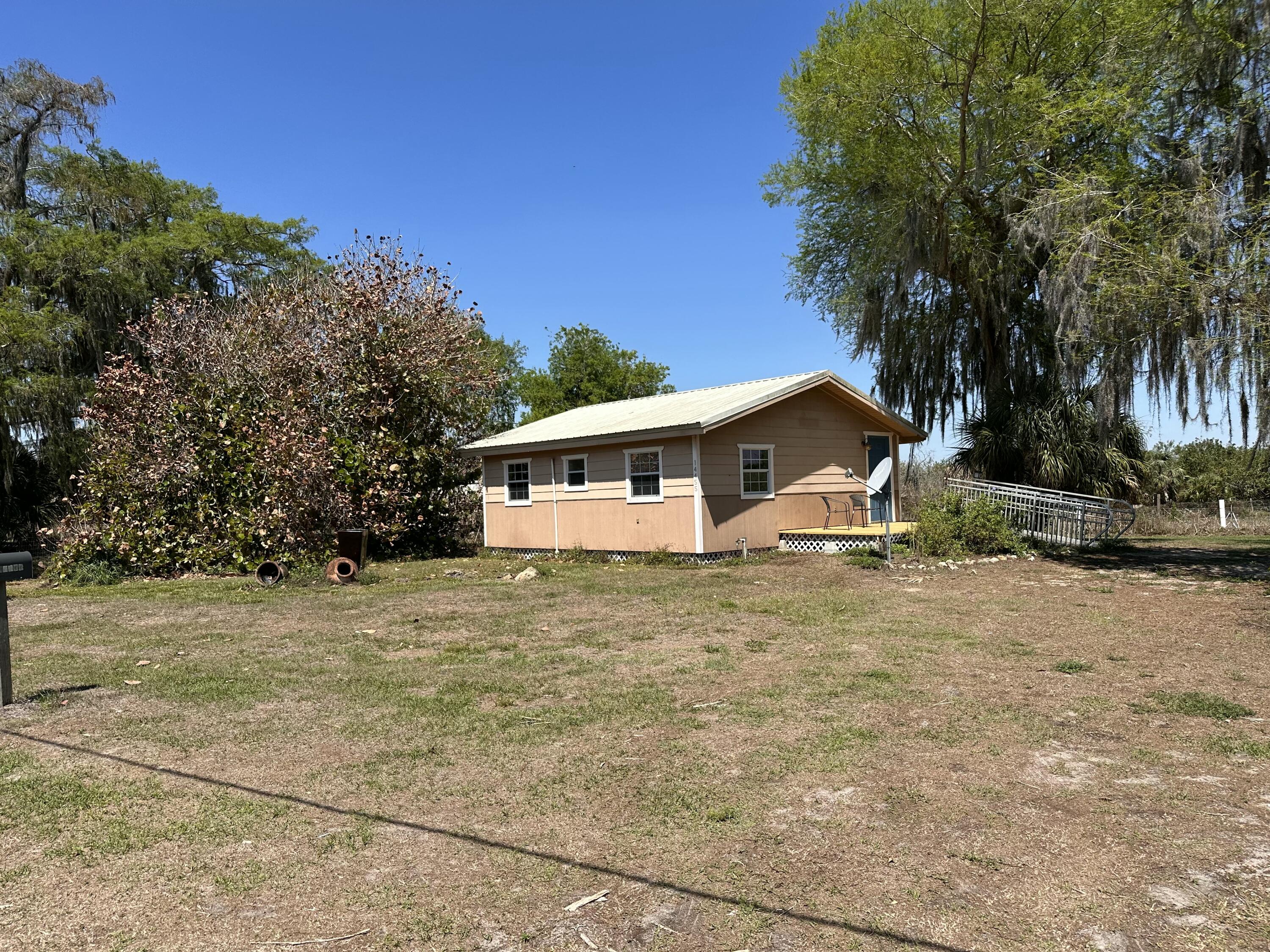 14455 Highway 78 Okeechobee, FL 34974 - Photo 9 of 14 a white house that has a tree in front of it