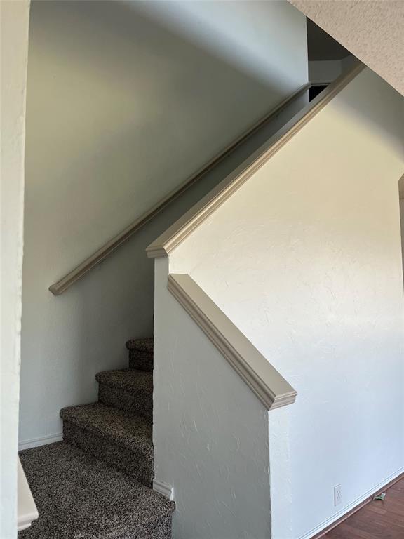 7929 Park Ridge Drive Fort Worth, TX 76137 - Photo 5 of 13 Carpeted stairway featuring a half-wall with decorative trim and a handrail