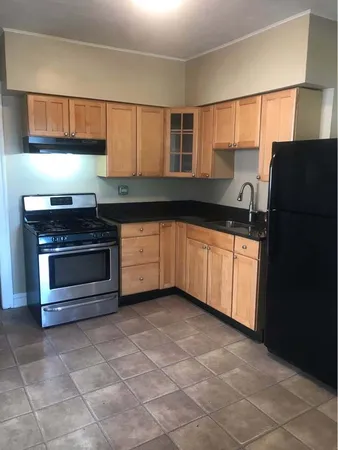 a kitchen with granite countertop a stove a sink and a refrigerator