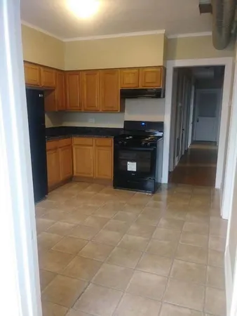 a kitchen with granite countertop a stove and cabinets