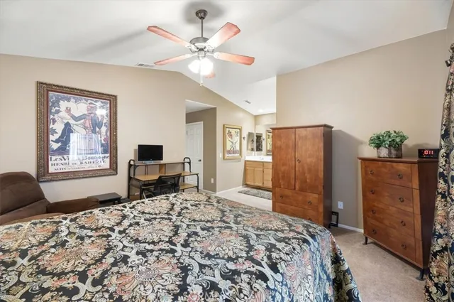 a bedroom with a bed dresser and a flat tv screen