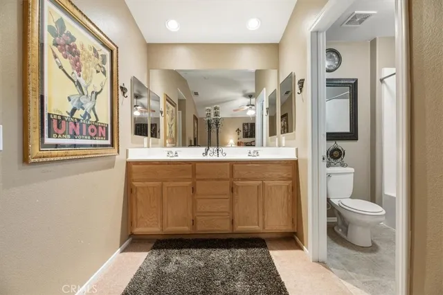 a spacious bathroom with a toilet a sink and a mirror