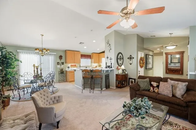 a living room with furniture kitchen view and a chandelier