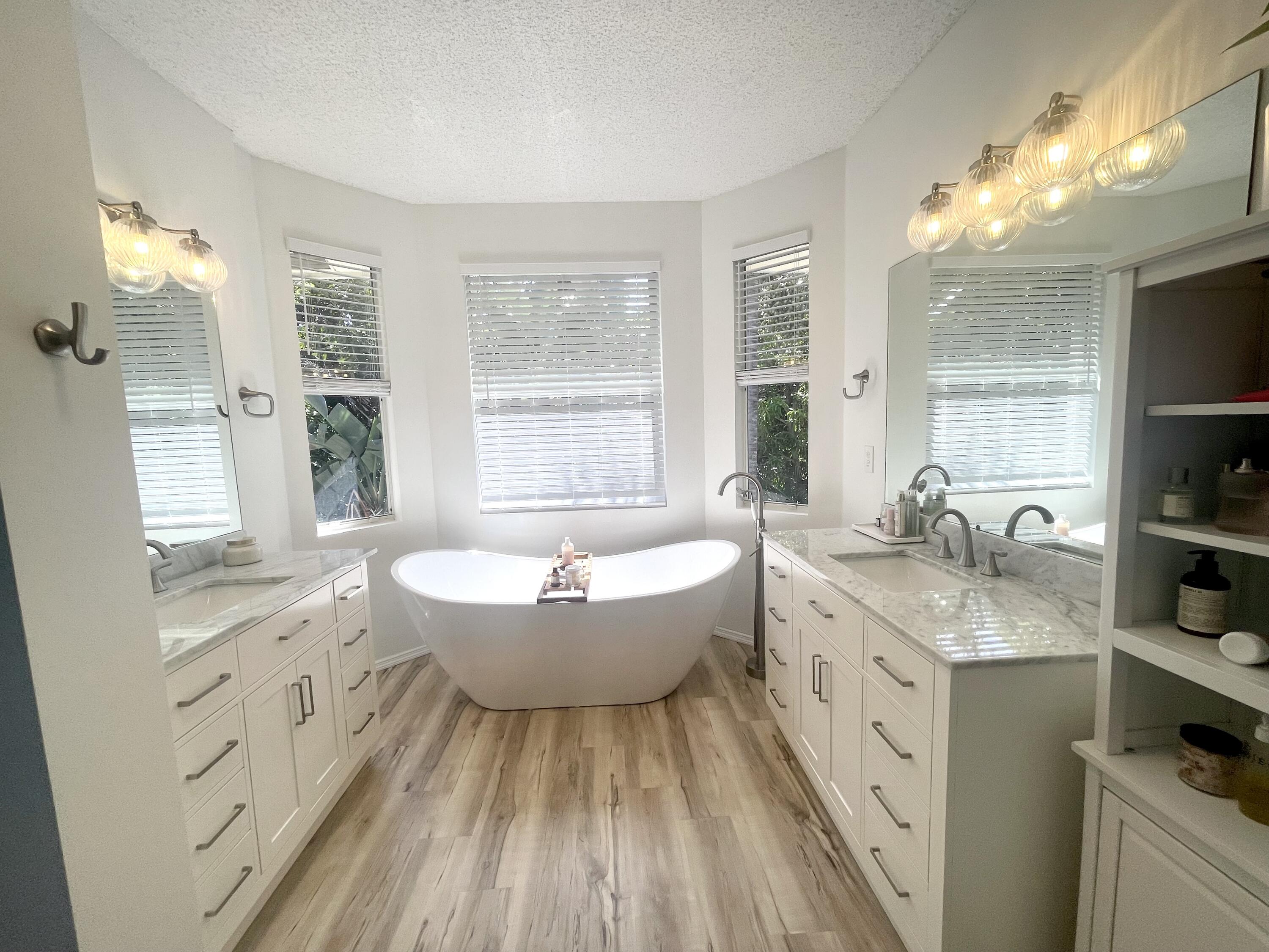 2033 Staysail Lane Jupiter, FL 33477 - Photo 3 of 40 a spacious bathroom with double vanity a granite countertop a sink a toilet a mirror and shower