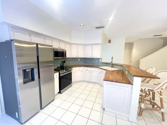 a kitchen with stainless steel appliances granite countertop a refrigerator and a stove top oven