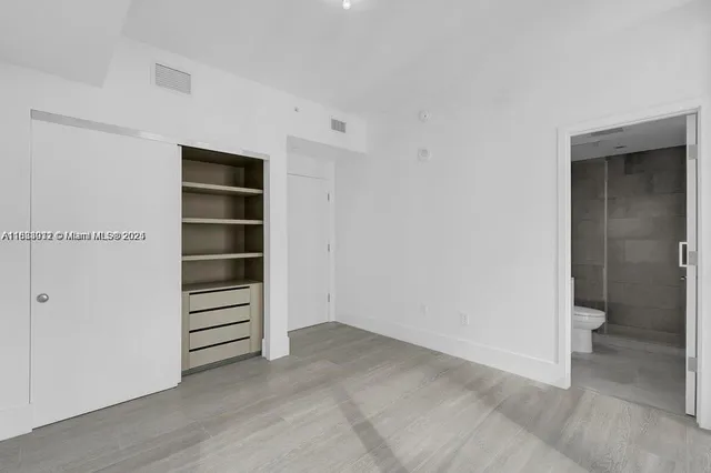 a view of walk in closet with empty racks