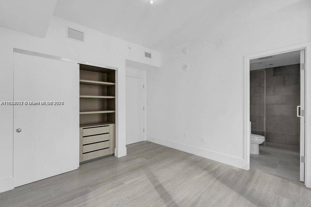788 Northeast 23rd Street, Unit 1402 Miami, FL 33137 - Photo 13 of 42 a view of walk in closet with empty racks