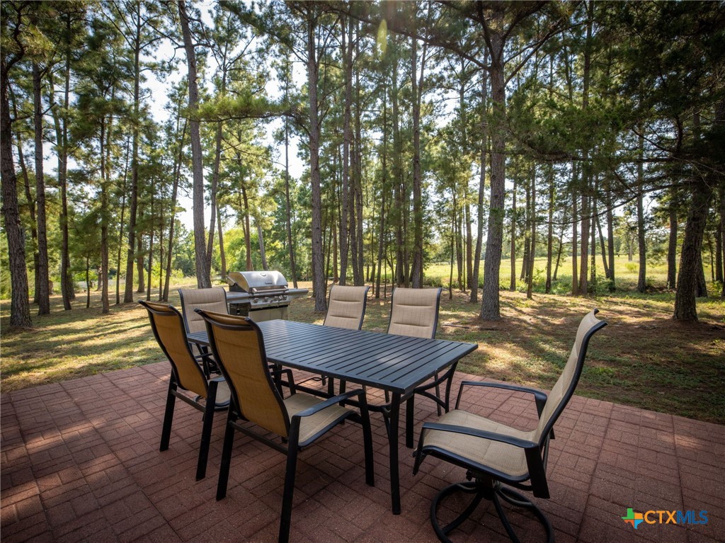 1031 Angel Lake Estates Road Alleyton, TX 78935 - Photo 16 of 47 a view of a patio with table and chairs and couches with large trees