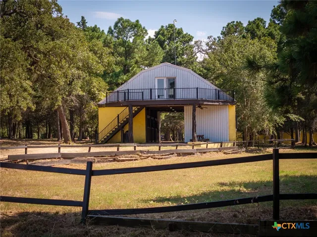 a view of a house with backyard and trees