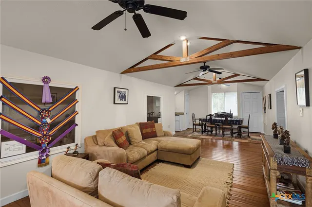 a living room with furniture a ceiling fan and a rug