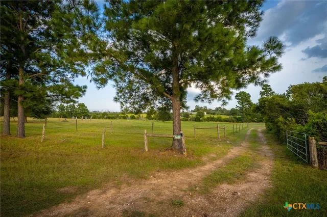 an aerial view of residential house with outdoor space and trees all around