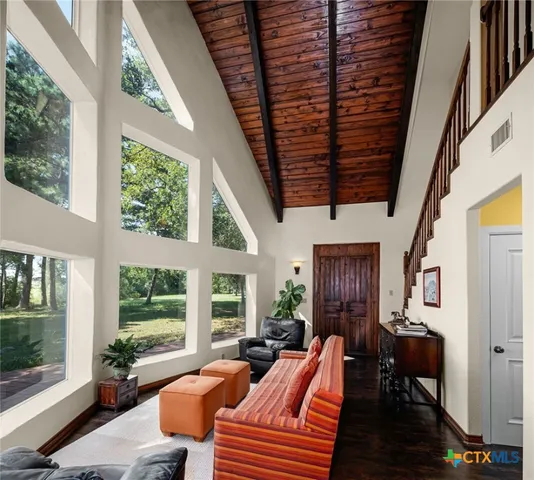 a living room with furniture a ceiling fan and a large window