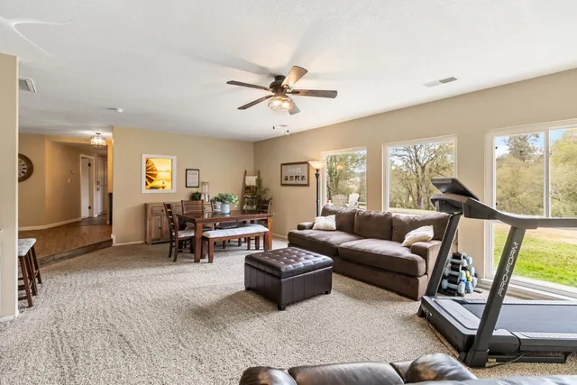 a living room with furniture and floor to ceiling windows