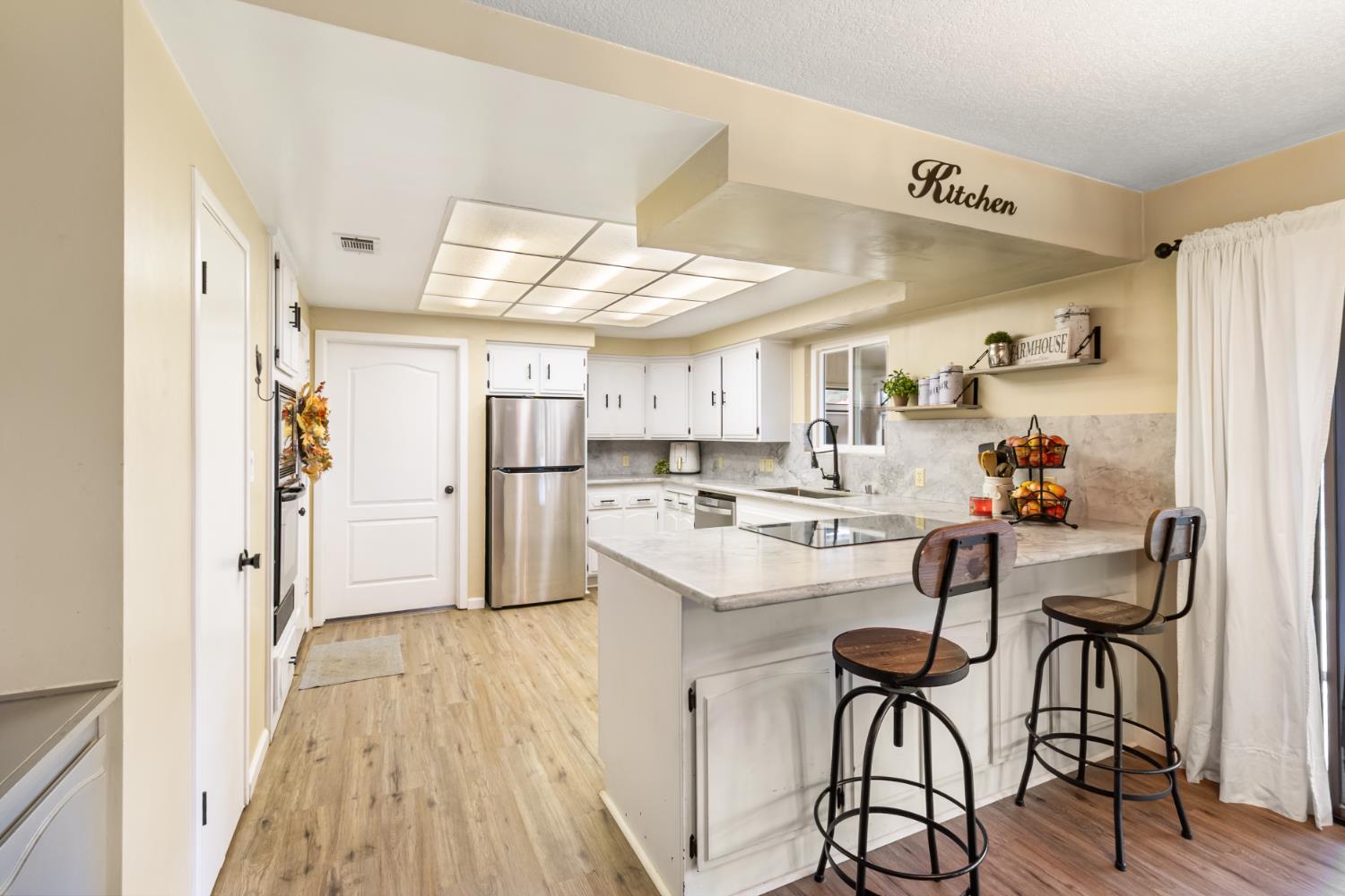 22800 Latrobe Road Plymouth, CA 95669 - Photo 22 of 81 a kitchen with refrigerator cabinets and wooden floor