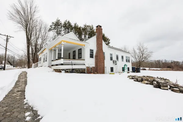a large white building with a view of snow on the road