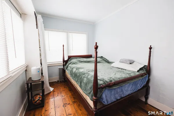 a bed sitting in a bedroom next to a window