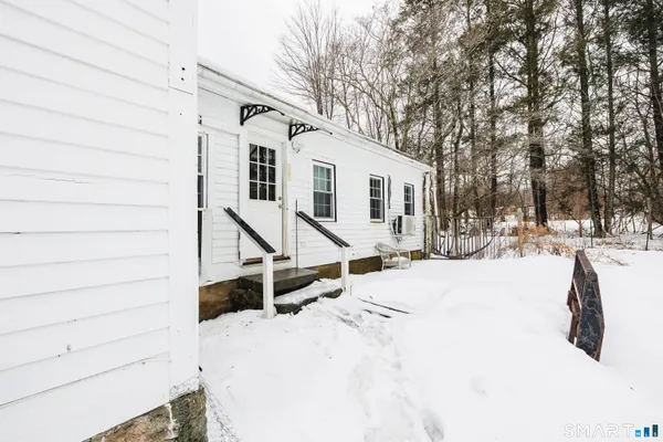 a view of a house with snow on the road
