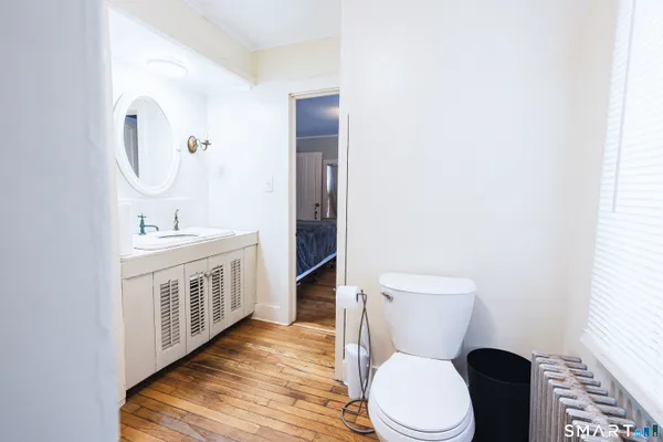 a bathroom with a toilet a sink a vanity and mirror
