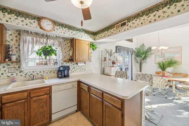 a kitchen with a sink a counter space and a view of living room