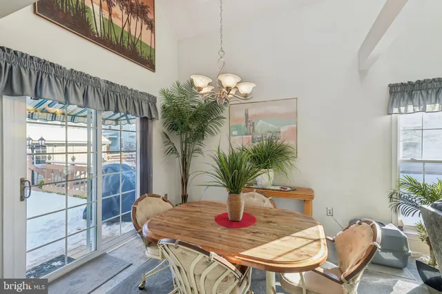 a dining room with furniture potted plants and wooden floor