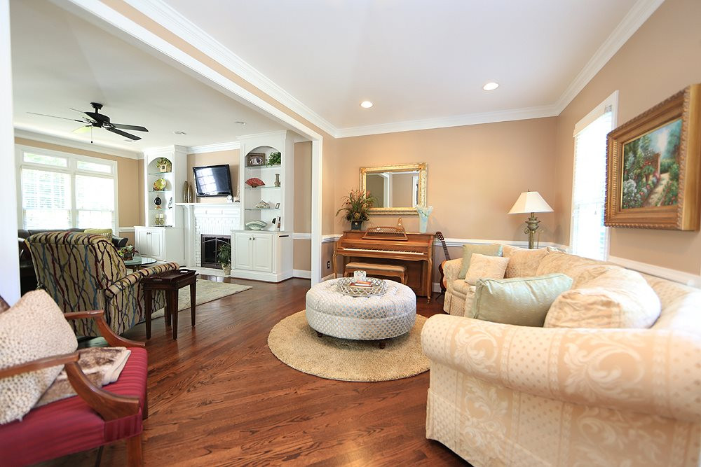 9101 Tealby Place Raleigh, NC 27615 - Photo 5 of 30 Living Room open to family room with crown, chair rail and custom hardwood floors. Living Room