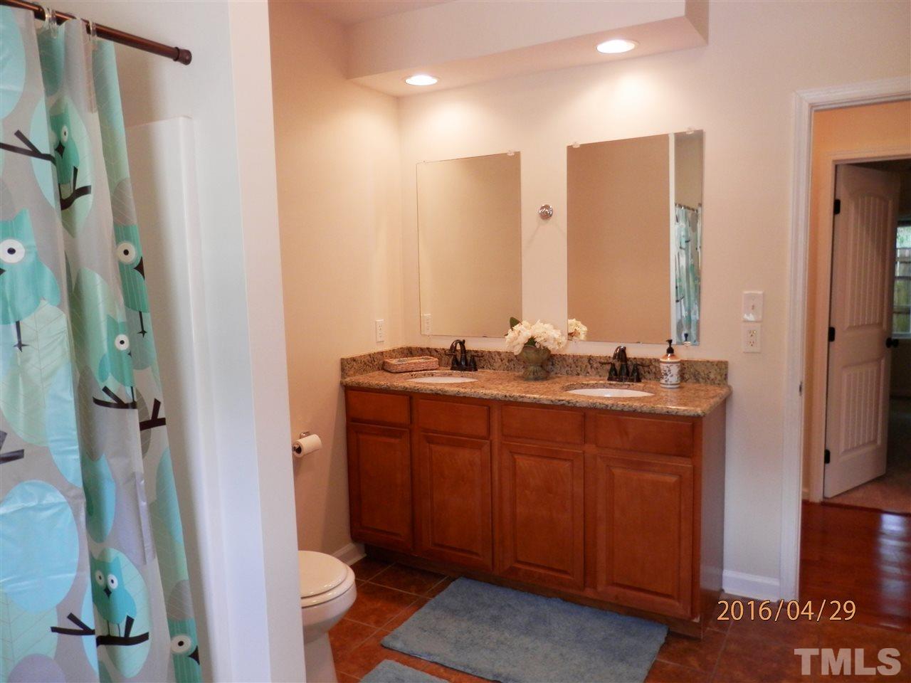 817 East Davie Street Raleigh, NC 27601 - Photo 12 of 25 a bathroom with a double vanity sink and a mirror