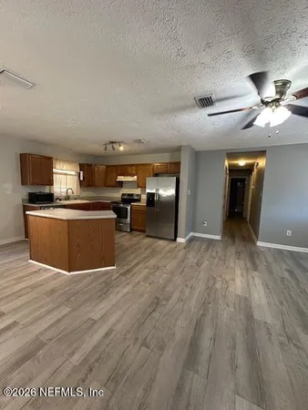 a view of a kitchen with a sink a refrigerator and a fireplace