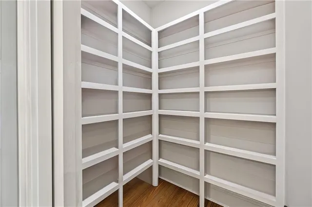 a spacious bedroom with a bed and wooden floor