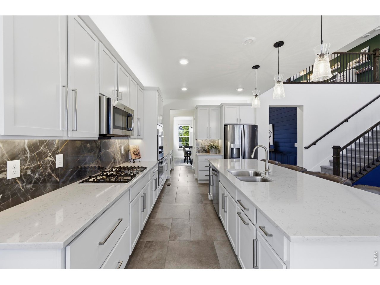 2910 Water View Street Timnath, CO 80547 - Photo 15 of 50 a large white kitchen with stainless steel appliances sink stove and cabinets